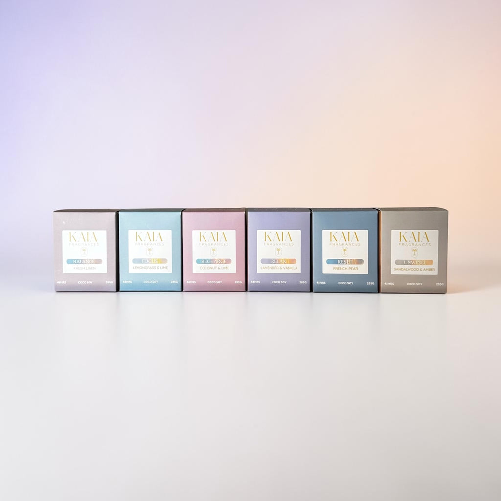 Six boxes of KAIA coco soy candles from the State Collection on a gradient background