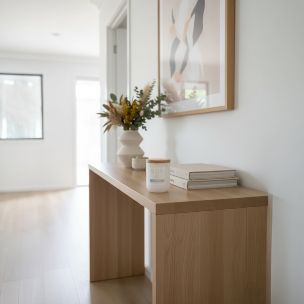 KAIA coco soy candle on Wooden console table with decor items in a modern interior setting